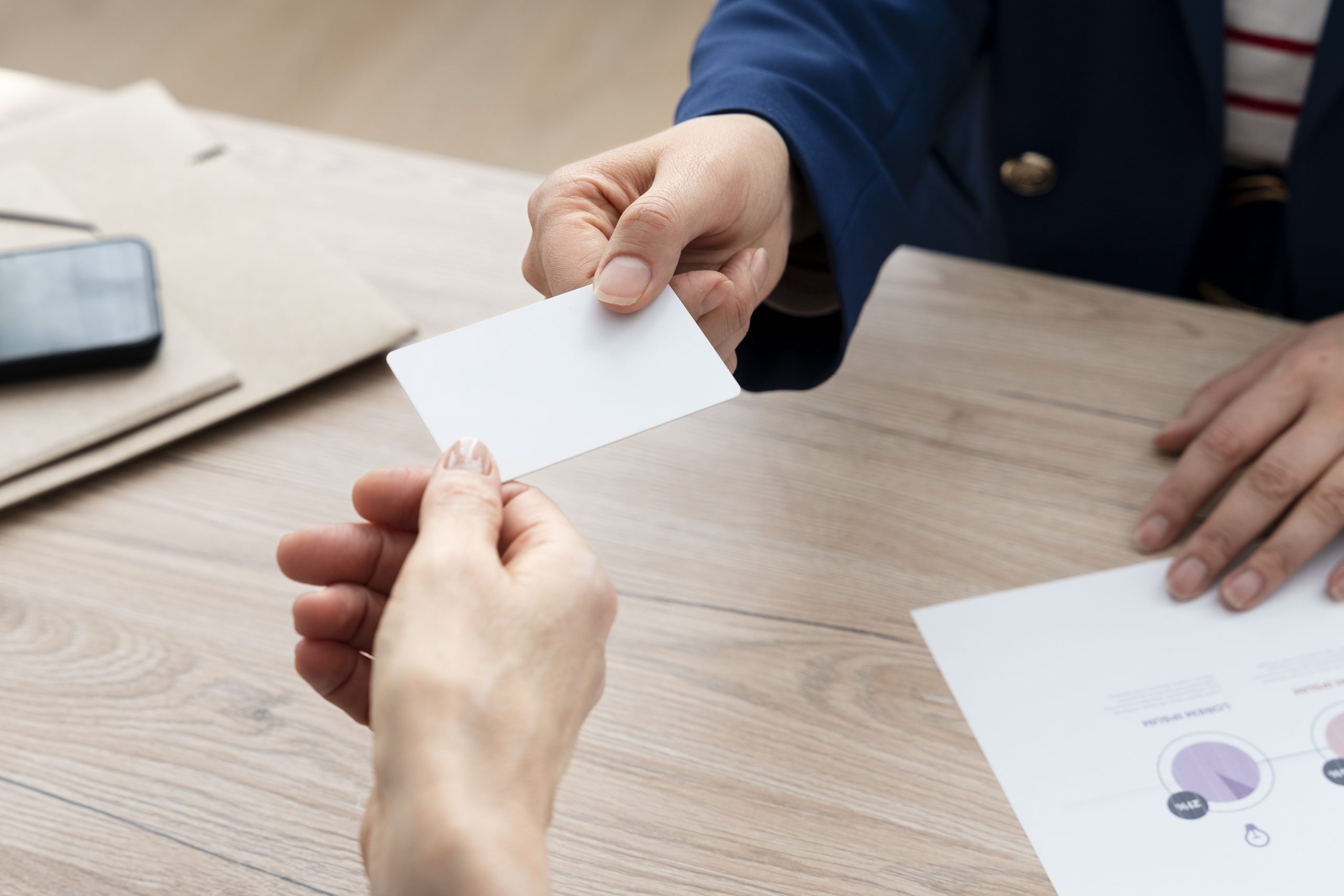high-angle-hands-holding-business-cards